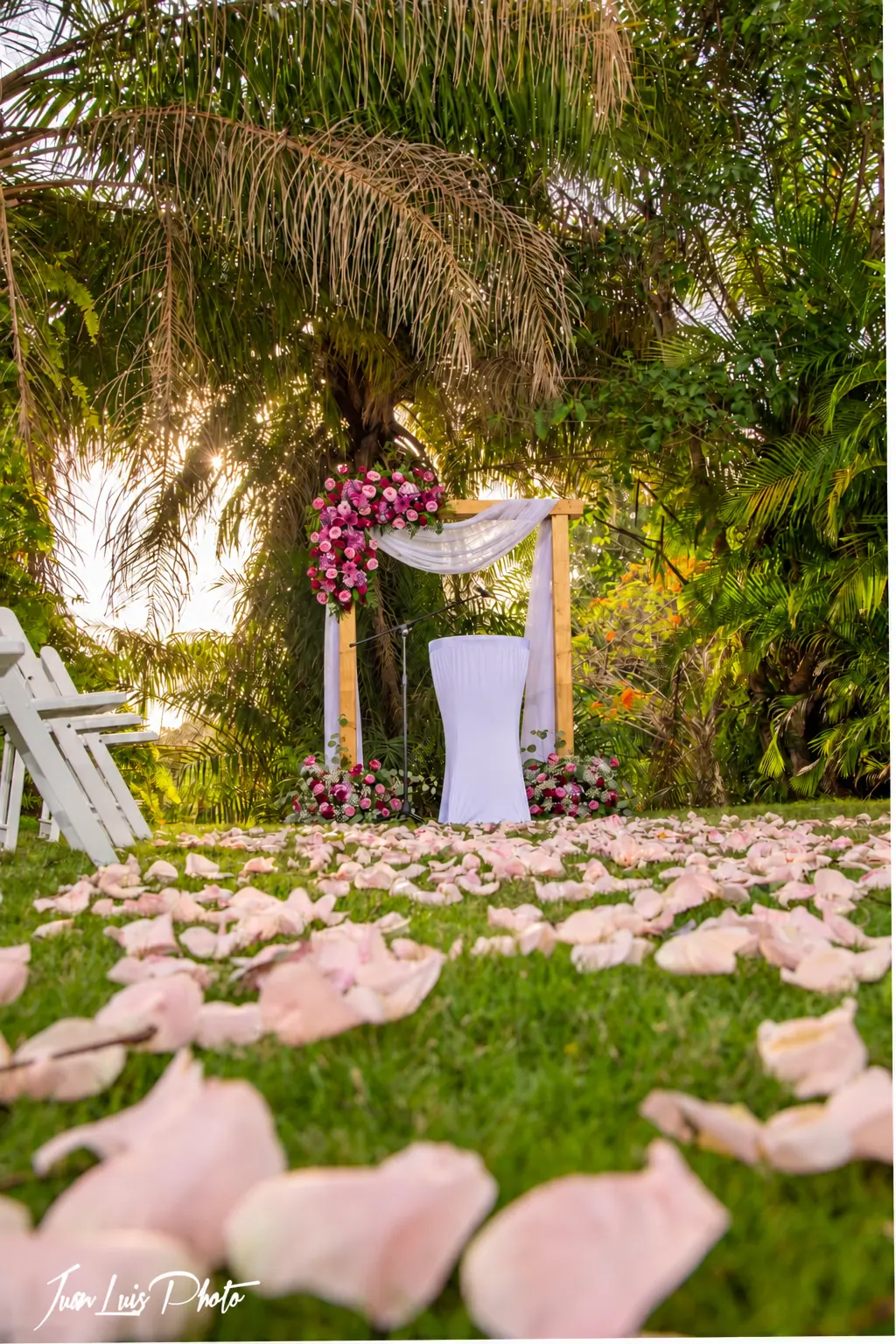 Wedding ceremony with a floral arch in Villa Bonita gardens
